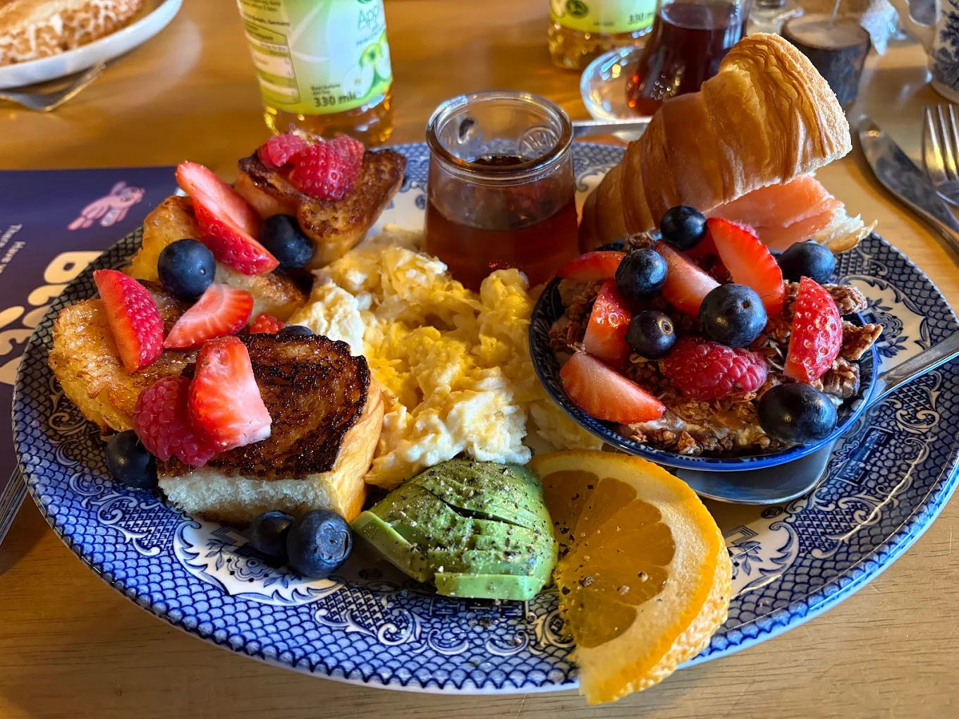 A generous Peony Café brunch platter with French toast, scrambled eggs, granola and fresh fruit