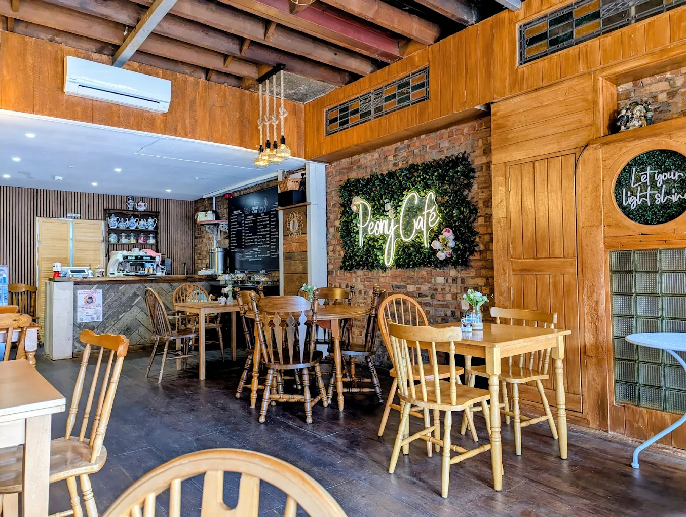 Inside Peony Café - the neon sign glowing above rustic wooden tables